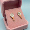 Pair of earrings in a pink jewelry box on a light blue background